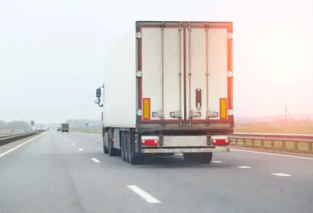 クール便トラックと出荷用の段ボール箱でミニトマトを配送するイメージ